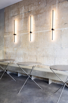 Salle restaurant Galetezen Paris IX — banquette pierre de taille appliques noires tables inox — Bilal Deshayes architecte d'intérieur