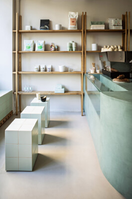 Vue d'ensemble Belén Bakery Café Paris XVI — comptoir enduit vert étagères chêne tabourets carreaux — Bilal Deshayes architecte d'intérieur