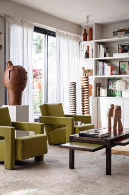 Salon appartement Amelot Paris XI — fauteuils vintage vert sculpture céramique terracotta bibliothèque — rénovation résidentielle Bilal Deshayes architecte d'intérieur 