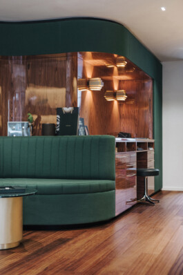 Intérieur boutique March LAB Soho Londres — canapé courbe vert bureau client palissandre luminaires laiton — retail design luxe Bilal Deshayes architecte d'intérieur Paris 