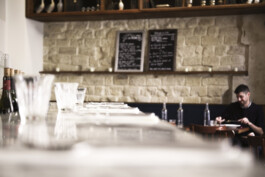 Comptoir bar Le Comptoir de la Gastronomie Paris Ier rue Montmartre — pierre de taille boiseries tablettes — rénovation Bilal Deshayes architecte d'intérieur Paris