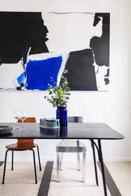 Table à manger noire avec grande toile abstraite bleue et noire en arrière-plan, appartement Paris XIe — Bilal Deshayes architecte d'intérieur 