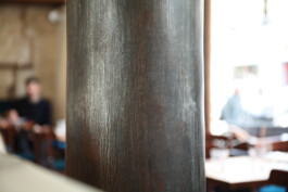 Détail colonne bois sombre Le Comptoir de la Gastronomie Paris Ier — ambiance brasserie historique 1894 — rénovation Bilal Deshayes architecte d'intérieur Paris