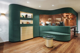 Espace vente March LAB Soho Londres — cloison organique verte canapé courbe meuble laiton boiseries palissandre — Bilal Deshayes architecte d'intérieur Paris