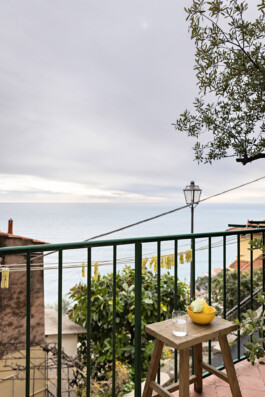 Balcon avec vue mer, rambarde verte et tabouret en bois, maison duplex Grimaldi Superiore Ligurie Italie — Bilal Deshayes architecte d'intérieur