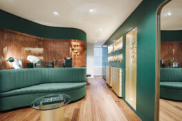 Salon privé boutique March LAB Soho Londres — canapé courbe vert banquette boiseries palissandre laiton — retail horlogerie luxe Bilal Deshayes architecte d'intérieur Paris