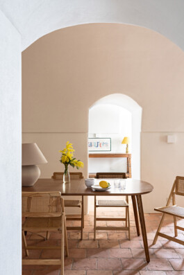 Salle à manger sous voûte avec table en noyer, chaises cannées et mimosa, maison Grimaldi Ligurie — Bilal Deshayes architecte d'intérieur