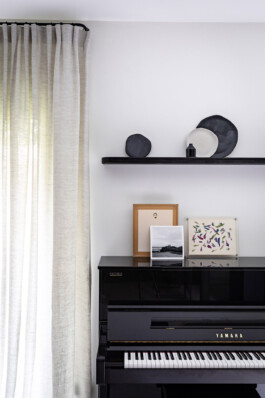 Détail salon piano Yamaha étagère noire céramiques maison Neuilly-sur-Seine — rénovation résidentielle Bilal Deshayes architecte d'intérieur Paris