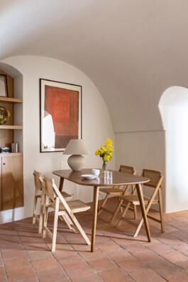 Salle à manger sous voûte avec table en noyer, chaises cannées et mimosa, maison Grimaldi Ligurie — Bilal Deshayes architecte d'intérieur