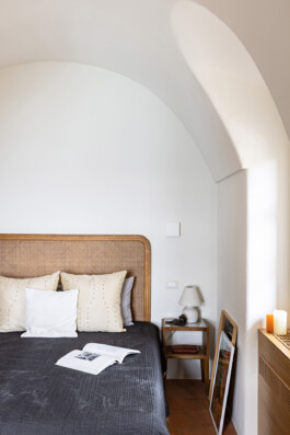Chambre avec voûte en arc et tête de lit en rotin, maison rénovée Grimaldi Superiore Ligurie — Bilal Deshayes architecte d'intérieur