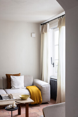 Salon lumineux avec tomettes, fauteuils bouclé et grande fenêtre donnant sur le village, Grimaldi Superiore — Bilal Deshayes architecte d'intérieur