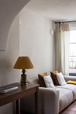 Coin salon avec console en bois tourné, lampe ocre et canapé modulaire, maison Grimaldi Superiore Italie — Bilal Deshayes architecte d'intérieur