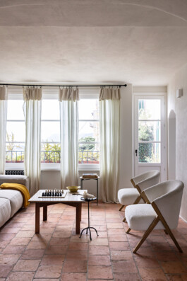 Salon avec canapé beige, plaid ocre et table en travertin, maison rénovée Grimaldi Superiore Italie — Bilal Deshayes architecte d'intérieur