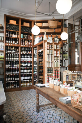 Épicerie fine cave à vins Le Comptoir de la Gastronomie Paris Ier — étagères boiseries table en bois carreaux ciment — rénovation Bilal Deshayes architecte d'intérieur Paris